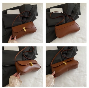 Détail d'un sac sous le bras vintage en cuir marron avec fermoir doré et design courbé