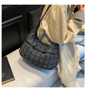 Detailed view of black quilted puff tote bag with premium stitched texture and zippers