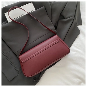 Dettaglio borsa sottobraccio in pelle bordeaux granata con tasca piatta sul retro borsa