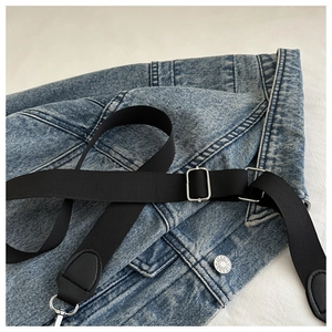 Détail du sac à bandoulière en denim bleu avec sangle en nylon et boucle en métal argenté