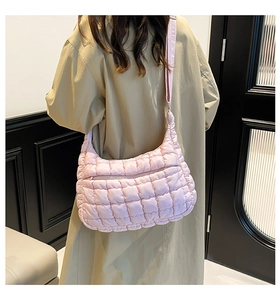 Detail of pink quilted hobo bag featuring padded puffer texture and wide shoulder strap