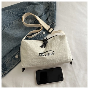 Detail of white wrinkled textured crossbody bag with adjustable strap and brand logo