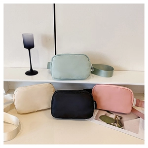 Detailed display of four colorful oxford fabric crossbody bags on a white platform