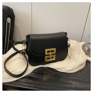 Detail shot of black leather saddle bag with a golden square interlocking hardware clasp
