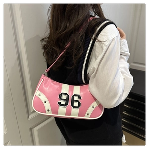 Detail of pink and white underarm bag with 96 embroidery and stud accents on model