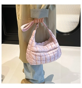 Detailed view of pink quilted puffer tote bag with front zipper and adjustable shoulder strap