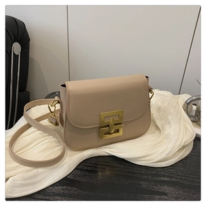 Detail of beige leather crossbody bag featuring a golden geometric clasp and adjustable strap