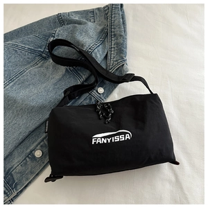 Detail of black nylon crossbody bag with white brand logo on wrinkled fabric background