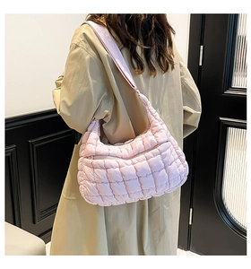 Rear view of pink quilted cloud tote bag with wide shoulder strap worn by a model