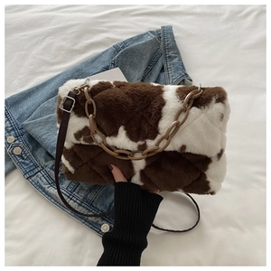 Détail du sac en fausse fourrure à motif vache avec matelassage et chaîne en résine