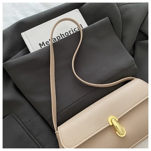 Dettaglio borsa a spalla in pelle martellata beige con fibbia ovale dorata e stile chic