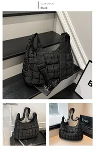 Detail of black quilted puffer tote bag showing stitching texture and padded shoulder strap