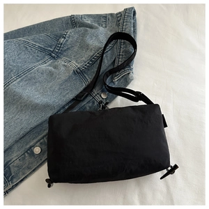 Detail of black nylon crossbody bag with adjustable drawstring and sleek tech fabric