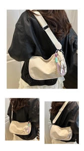 Détail du sac croissant blanc cassé brodé avec cordons décoratifs violet et menthe