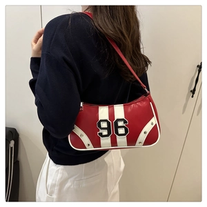 Detail of red retro underarm bag with white stripes and number 96 on a female model