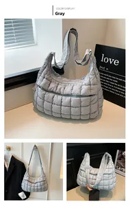 Macro detail of gray quilted puffer tote bag with glossy finish and zip pocket