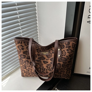 Detailed view of the leopard print tote bag with leather straps and gold rivet accents