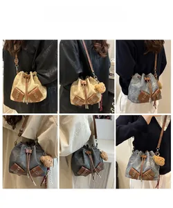 Detail view of retro drawstring bucket bags in beige, grey, and blue with bear charm