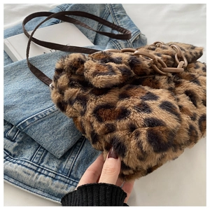 Détail du sac à main léopard en fausse fourrure avec chaîne sur fond en jean