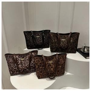 Four colors of leopard print tote bags arranged on modern geometric pedestals
