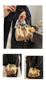 Detail of drawstring canvas bucket bag with leather trim and cute brown bear charm