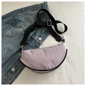 Gros plan détaillé du sac bandoulière croissant en nylon violet avec sangle réglable
