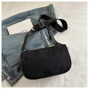 Détail d'un sac bandoulière demi-lune en nylon noir avec sangle en tissu réglable