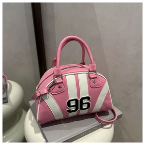 Vue détaillée du sac à main rétro rose avec applique 96 sur un piédestal blanc