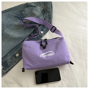 Detail of purple nylon crossbody bag with adjustable strap and smartphone size reference