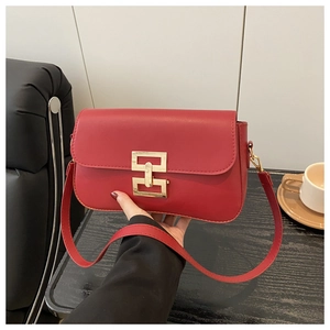 Detail of red rectangular crossbody bag with a geometric gold metal magnetic buckle