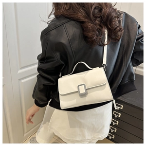 French design white crossbody square bag with silver buckle worn by a model in leather jacket
