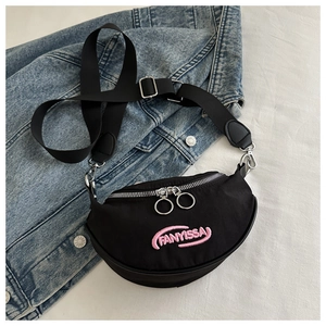 Détail du sac banane en nylon noir avec logo brodé rose et fermetures éclair à anneaux dorés