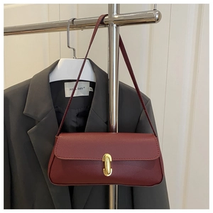 Dettaglio borsa baguette bordeaux in pelle a grana litchi con chiusura in metallo dorato