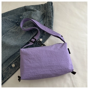 Detailed close-up of purple water-resistant nylon crossbody bag with adjustable strap