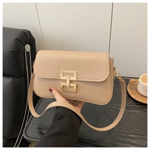 Close-up of beige leather crossbody bag with elegant gold rectangular interlocking clasp