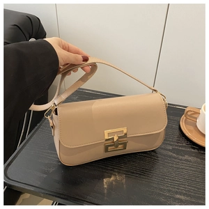 Detail of light brown crossbody bag featuring golden interlocking buckle and smooth texture