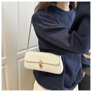 Elegante borsa baguette beige in pelle motivo litchi portata a spalla da una modella