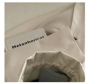 Dettaglio della borsa con coulisse in pelle PU bianco crema con interno e trama morbida