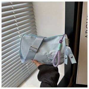 Détail du sac polochon en toile bleu clair avec broderie coeur et cordelette violette