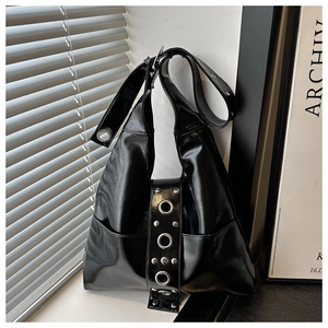 Detalle de bolso hobo de cuero PU negro brillante con ojales plateados y estilo punk