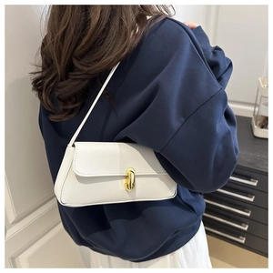 Dettaglio borsa a spalla in pelle bianca martellata con elegante chiusura a scatto dorata