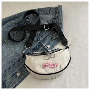 Vue détaillée du sac bandoulière croissant crème avec broderie et sangle noire