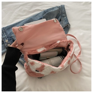 Détail de l'intérieur du sac en peluche rose et blanc avec ses boutons aimantés