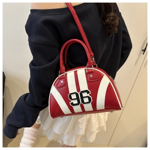 Détail du sac bowling rayé rouge et blanc avec écusson numéro 96 et clous en métal
