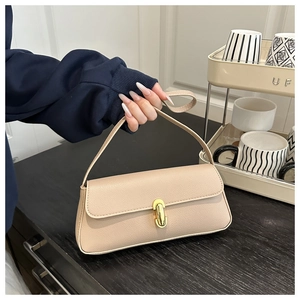 Dettaglio borsa sottobraccio in pelle beige con fibbia dorata e tracolla in pelle