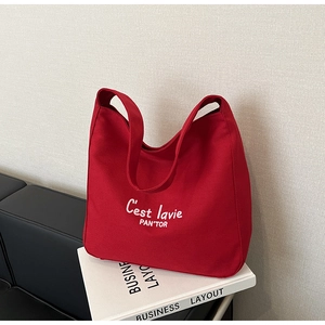 Gros plan du sac fourre-tout en toile rouge montrant le texte imprimé et la texture du tissu