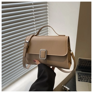 Close-up of khaki structured handbag with silver square buckle and top handle