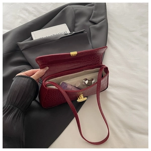 Detail view of burgundy crocodile pattern baguette bag showing inner storage for essentials