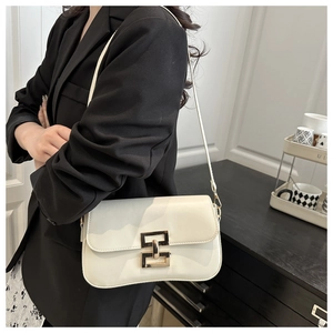 Detail of cream-colored minimalist underarm bag with gold metal buckle on black suit