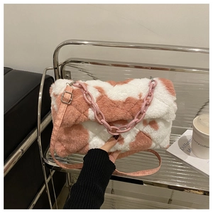 Détail du sac en peluche à damier rose et blanc avec grosse chaîne sur une étagère
